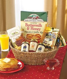 a basket filled with food sitting on top of a table next to a glass of orange juice