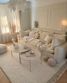 a living room filled with white furniture and pillows on top of a carpeted floor