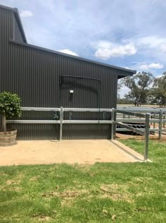 a basketball hoop on the side of a building with grass and trees in front of it