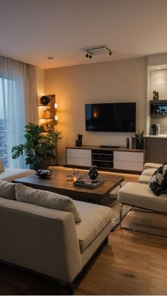 a living room filled with furniture and a flat screen tv mounted to the side of a wall