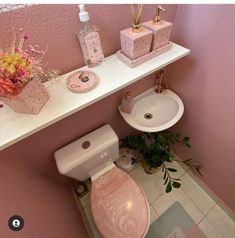 a bathroom with pink walls and white counter top, toilet and sink in the corner