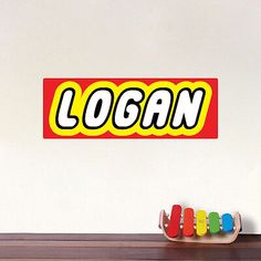 the name logan is written in large letters on a wall above a toy boat