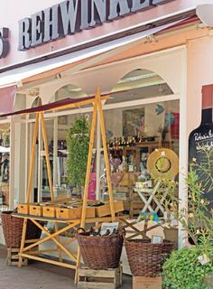 a store front with baskets and plants outside