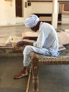 a man sitting on a bench reading a newspaper