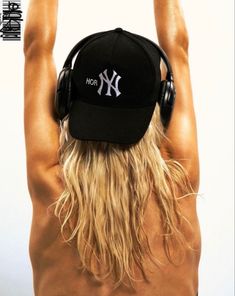 a man with long blonde hair wearing headphones and a new york yankees baseball cap