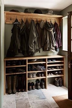 a coat rack with shoes and coats hanging on it