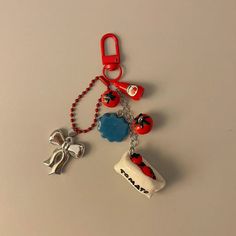 a red and blue keychain with charms attached to it on a white surface