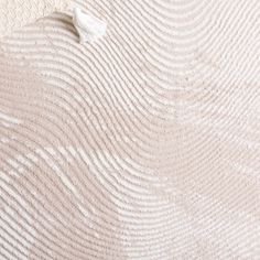 the textured fabric is white and beige, with waves on it's surface