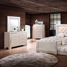 a white bed sitting in a bedroom next to a dresser with drawers and a mirror