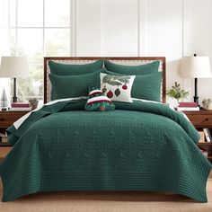 a green comforter set with christmas decorations on it