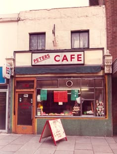 there is a sign that says peter's cafe in front of the storefront