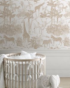 a baby's crib in front of a wall with zebras and giraffes on it