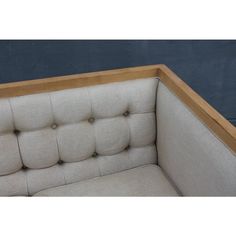 an upholstered couch with buttons on the armrests and wood trimming