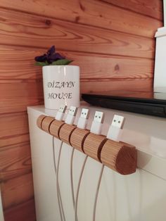 a white mug sitting on top of a stove next to four wooden plugs in front of a wood paneled wall