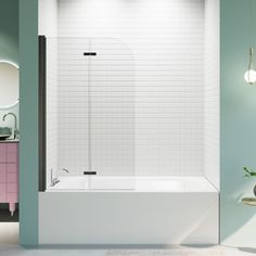 a white bath tub sitting next to a sink in a bathroom with green walls and pink cabinets