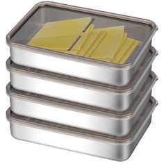 three metal trays with yellow sticky notes on them are stacked up in front of each other