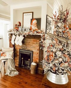 a decorated christmas tree sitting in front of a fire place with stockings on the mantel