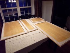 three pieces of wood sitting on top of a wooden table in front of a window