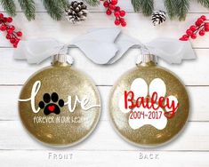 two personalized christmas ornament with dog's name and paw prints on them