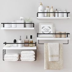 two shelves with towels, soaps and other items on them in a bathroom setting