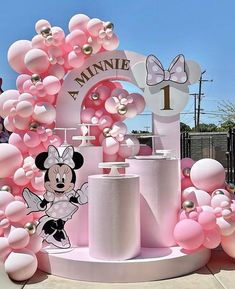 a minnie mouse birthday party with balloons and decorations