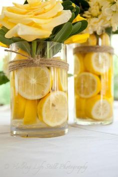 two vases filled with lemon slices and flowers