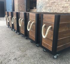 four wooden boxes with ropes on them sitting in front of a brick building