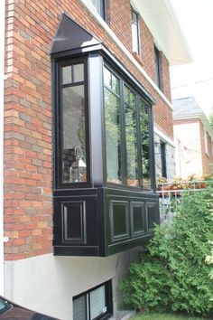 a black window on the side of a brick building