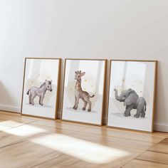 three framed pictures of animals on the wall in an empty room with hard wood flooring