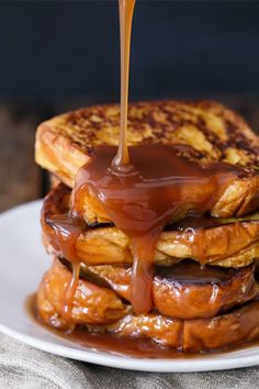 a stack of french toast covered in chocolate syrup and drizzled with caramel