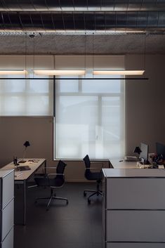 an empty office with two desks and chairs