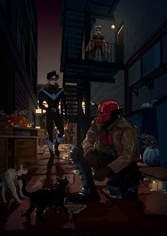 a man in a red helmet kneeling down next to a black cat and a dog