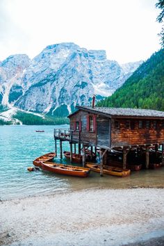 there is a boat dock with two boats in the water and a house on stilts