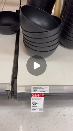 black bowls are stacked on top of each other for sale at the store's counter