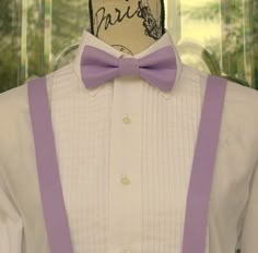 a mannequin wearing a white shirt and purple suspenders with a bow tie