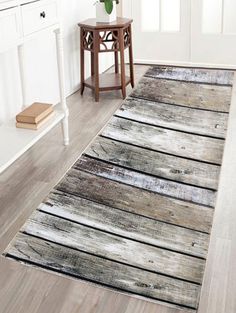 a white and gray rug with wooden planks on the floor in front of a door