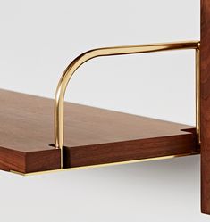 a close up of a shelf with a wooden surface and brass metal handles on it