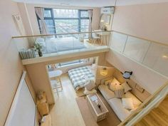 an aerial view of a living room and bedroom from the second floor, looking down