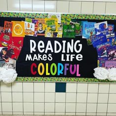 a sign that reads reading makes life colorful on the side of a tiled wall in a public restroom