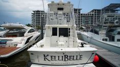 a white boat docked at a marina with other boats