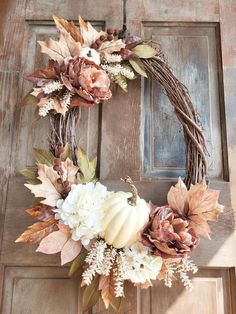 a wreath with flowers and leaves on the front door