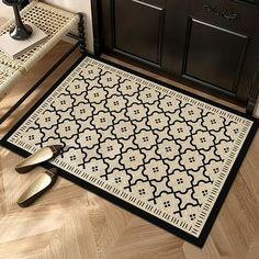 a black and white area rug on the floor next to two chairs with matching handles