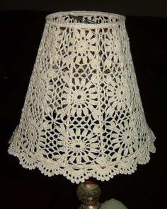 a white crocheted lamp shade sitting on top of a table