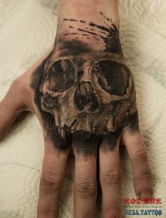 a man's hand with a skull tattooed on it