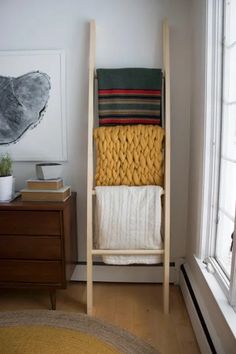 a towel rack in the corner of a room next to a window with a painting on it