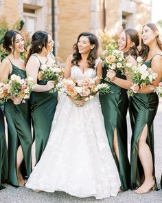 a group of women standing next to each other wearing green dresses and holding bouquets