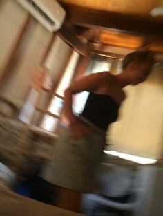 a blurry photo of a person standing in a kitchen next to a stove top oven