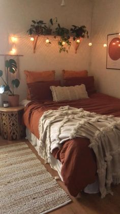 a bed sitting in a bedroom next to a window with lights on the wall above it