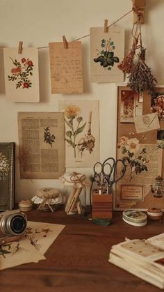 a wooden table topped with lots of pictures and papers on it's side, next to a camera