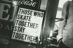 a man standing in front of a sign that says those who skate together stay together